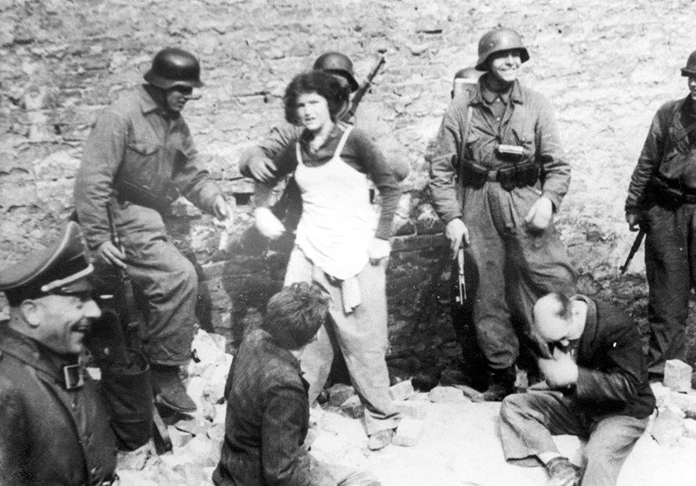 Three Jews being pulled out of a bunker.