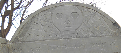 Headstone with alien-like figure at top.